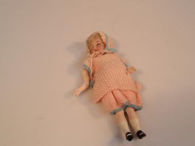 An early 20thC German bisque porcelain miniature baby doll with articulated body