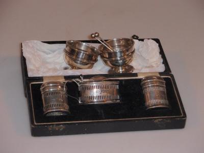 A George V silver three-piece cruet set of oval form with pierced decoration