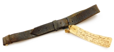 A 19thC leather strap reputed to have been worn by The Duke of Wellington at Waterloo, bearing a hand written label stating: This strap fastened The of Duke of Wellington's near side holsters at Waterloo, given me by O H Perry....from Strafield Saye, G H