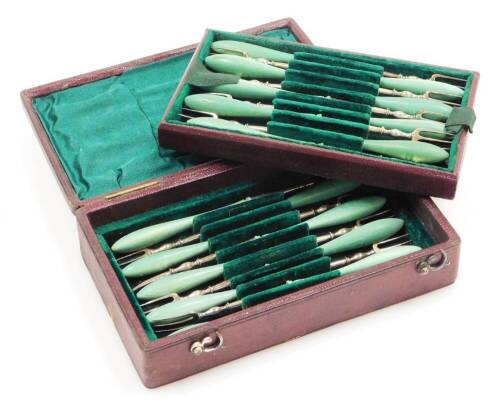 A set of eighteen late Victorian steel pickle forks, with turned green handles, in a fitted plush lined red leather case.