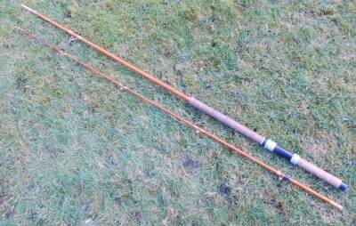 A mid 20thC two piece fibreglass salmon spinning rod, with bag.