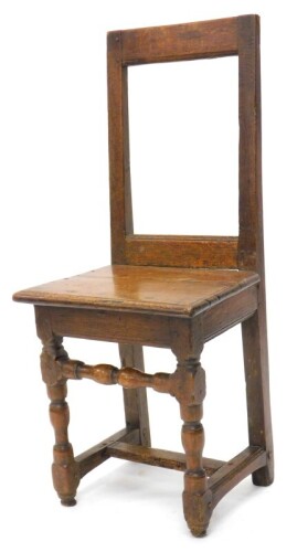 A 17thC French oak chair or back stool, with a plain rectangular back, solid seat with a moulded edge on part turned legs with stretchers, 39cm wide.