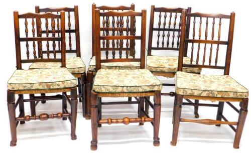 A Harlequin set of six 19thC Lancashire type spindle back dining chairs, each with a rush seat on turned tapering legs.