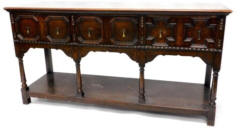 An early 20thC oak dresser base, the top with a moulded edge above three panelled drawers, on turned supports with pot board, 86cm high, 167cm wide.