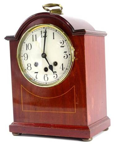 An early 20thC mahogany and boxwood strung mantel clock, with Westminster chime, the white dial with Arabic numerals and with a brass bezel on bun feet, 35cm high.