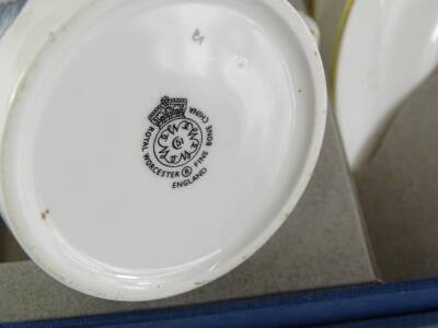 A Royal Worcester coffee service, decorated with purple and blue flowers on a plain white ground, printed mark in black to underside, original box. - 2