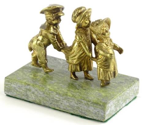 A gilt bronze figure modelled in the form of a procession of children, on a later marble base, possibly a car mascot, 11cm wide.