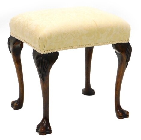 A walnut stool in mid-18thC style, with a padded seat on cabriole legs, carved with shells, etc., 49cm wide.