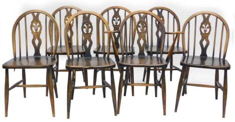 A set of seven Ercol stained beech Windsor type kitchen chairs, each with a pierced splat, a solid seat on turned legs with H stretcher, one with arms. (AF)