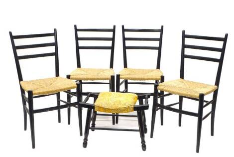 A set of four Italian ebonised ladderback chairs, each with a rush seat, gilt label for Rooksmoor Mills, Stroud, Gloucestershire, made in Italy, and a similar ebonised stool. (5)