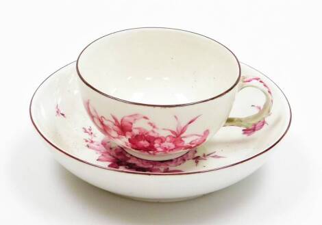 A porcelain cup and saucer, design of pink floral group, blue mark to underside, 11cm wide.