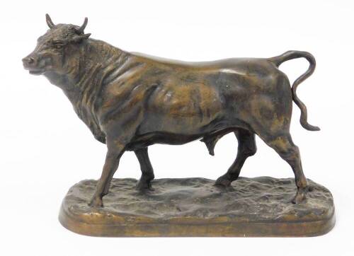 A 20thC bronze figure of a standing bull, on a rustic base, 24.5cm high.