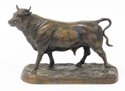 A 20thC bronze figure of a standing bull, on a rustic base, 24.5cm high.