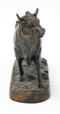 A 20thC bronze figure of a standing bull, on a rustic base, 24.5cm high. - 2