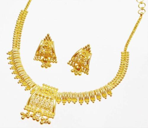 An Indian dress necklace and earring set, the necklace with central shaped panel with filigree work decoration and tassel ends, with ten rectangular bar sections to each side, on a hook clasp, with matching earrings, with screw on butterfly backs, yellow