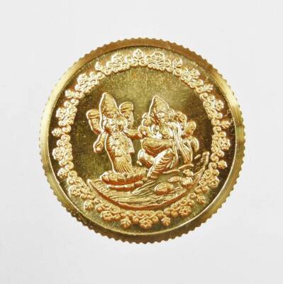 A Tanishq gold coin, depicting two Hindu figures, stamped 995 fine gold, 10g, in presentation sleeve and certificate of authenticity, 24kt, purchased 20/10/05.