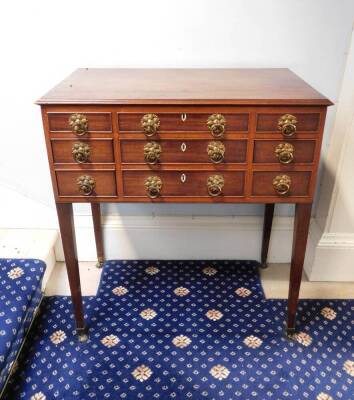 A George IV mahogany enclosed dressing table, the rectangular top with a moulded edge enclosing a fitted interior with a central adjustable mirror and various lidded compartments and recesses, the front with an arrangement of seven false drawers and doubl