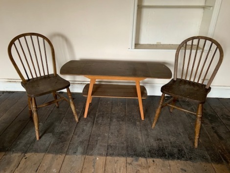 A teak drop leaf coffee table and two spindle back chairs.