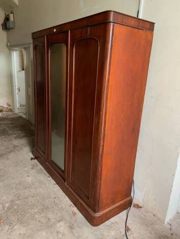 A Victorian mahogany triple wardrobe, with centred mirror door and fitted interior, 202cm high, 185cm wide. (rear flat)