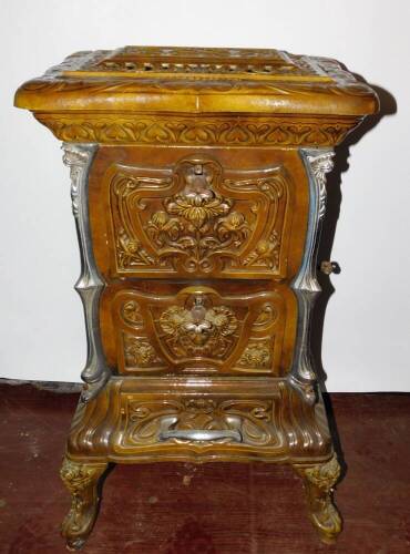 A French late 19thC Goudin cast iron polished metal and enamel stove, Model No 287., of serpentine form with a hinged cover and three floral moulded doors and drawers, raised on cabriole legs, 85cm high, 50cm wide, 38cm deep.