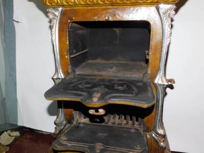 A French late 19thC Goudin cast iron polished metal and enamel stove, Model No 287., of serpentine form with a hinged cover and three floral moulded doors and drawers, raised on cabriole legs, 85cm high, 50cm wide, 38cm deep. - 3