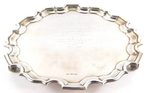 A George V silver pie crust salver, presentation engraved, raised on three leaf cast ball feet, Sheffield 1923, 26.00oz.