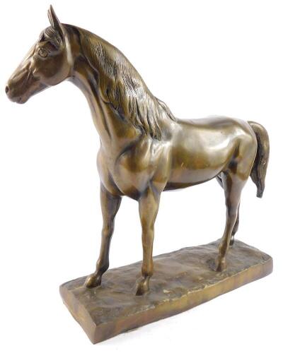 A filled bronze figure of a horse, modelled in standing pose, raised on a naturalistic rectangular base, 37cm high, 44cm wide.