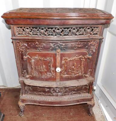 A French late 19thC cast iron and enamel wood burning stove Le Vosgien, No 258, by De Dietrich & Cie., Niederbronn., of serpentine form, the front and sides with a pierced grill moulded with cherubs' heads, the two doors and side panels moulded with castl