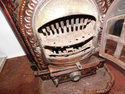 A French late 19thC cast iron and brown enamel Gallia stove, of bow fronted form, embossed with laurel wreaths and flaming torch, raised on a shaped hearth, 66cm high, 56cm wide, 43cm deep. - 4