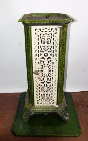 A French early 20thC cast iron and enamel conservatory heater, of canted square form, with pierced repeating foliate decoration, raised on four scroll feet, lid lacking, 75cm high, 33cm diameter.