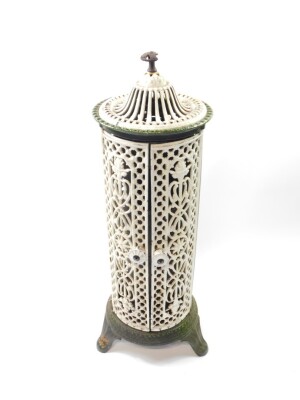 A Victorian white and green cast iron cathedral heater by Nestor Martin, with pierced floral and foliate decoration, the two doors opening to reveal a burner chimney, raised on three scroll feet, 84cm high, 26cm diameter.