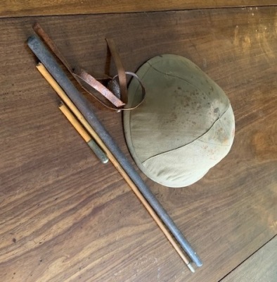 A British Army First World War period tin helmet, and canvas cover, and a swagger stick for the Somerset Light Infantry. (AF)