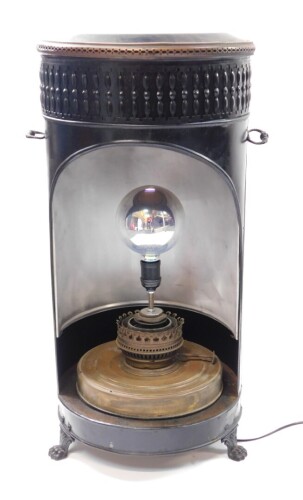 A Belgian early 20thC black tin and brass paraffin heater, converted to an electric floor lamp, of cylindrical form, raised on three paw feet, 72cm high, 37cm diameter.