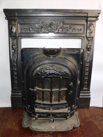 A French early 20thC cast iron La Salamandre cast iron fire, by E Chaboche & Cie, 26 Rue Rodier, Paris., of bow fronted form, raised on a shaped hearth, 74cm high, 57.5cm wide, 44cm deep., together with a cast iron fire surround, embossed with paterae, fl