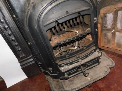 A French early 20thC cast iron La Salamandre cast iron fire, by E Chaboche & Cie, 26 Rue Rodier, Paris., of bow fronted form, raised on a shaped hearth, 74cm high, 57.5cm wide, 44cm deep., together with a cast iron fire surround, embossed with paterae, fl - 4