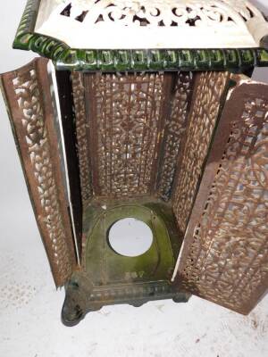 A French early 20thC cast iron and enamel conservatory heater, of canted square form with pierced foliate panels, raised on scroll feet, 95cm high, 44cm diameter. (AF) - 2