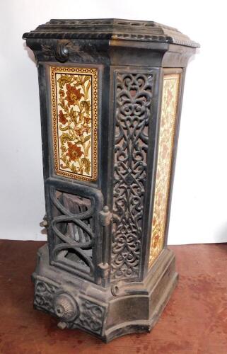 A French late 19thC cast iron and enamel Goudin stove, by Dequenne & Cie., of canted square form with pierced foliate panels, alternating with panels inset with floral pottery tiles, model no 78., 91cm high, 45cm diameter.