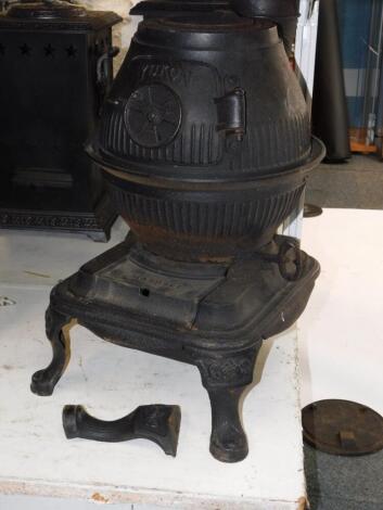 A Masport Yukon late 19thC cast iron pot belly stove, of fluted globe form, raised on an iron base and three cabriole legs, 58cm high, 34cm diameter.