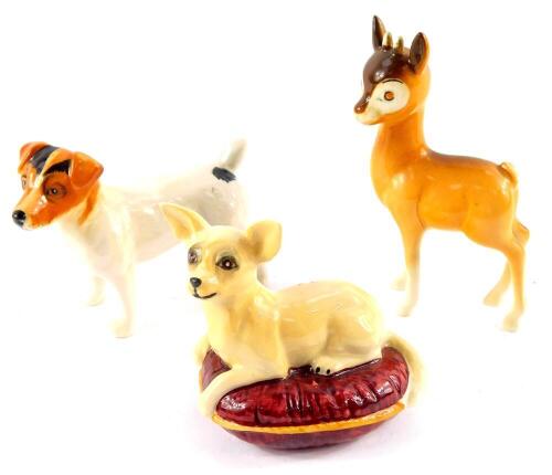 A Beswick Babycham deer, Jack Russell Terrier, and a figure of a Chihuahua, modelled lying on a maroon coloured cushion. (3)