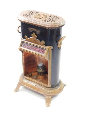 A Petrolux late 19thC black tin and brown enamel stove, with copper burner and glass chimney, moulded with repeating leaf decoration, raised on four scroll feet, 67.5cm high, 40cm wide, 33.5cm deep.