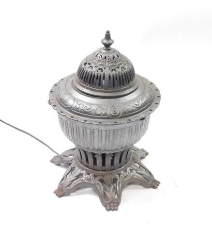 A Victorian cast iron Omega E gas stove converted to a lamp, of circular pierced and semi fluted form, with a pierced cover, raised on a six footed base, 48cm high, 32cm diameter.