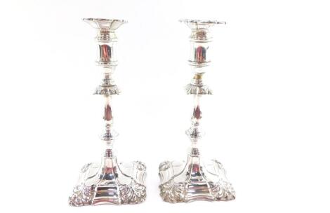 A pair of Edward VII loaded silver candlesticks, of turned form with embossed scroll decoration, Israel Sigmund Greenberg, Birmingham 1904, 25.50oz all, 24.5cm high.