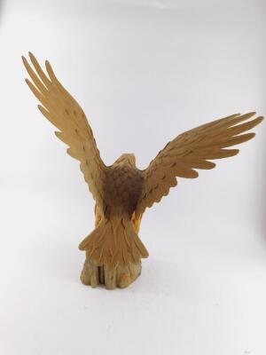 A wood effect plaster and wooden sculpture of an eagle, modelled with it's wings upright, perched on a wooden stump, 58cm high, 49cm wide. - 2