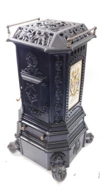 A cast iron heater, containing bottle gas, of canted square form, raised on ball and claw feet, 91cm high, 41cm wide.