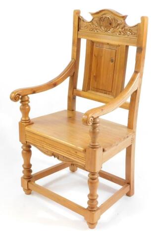 A pine Wainscot chair, with fan and foliate carved crest rail, rectangular panelled back, solid seat, raised on turned legs united by a box stretcher.