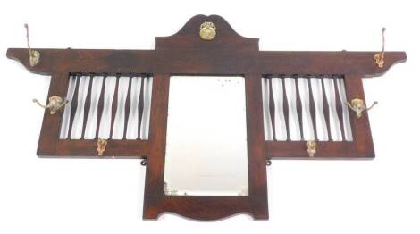 A late Victorian oak framed wall mounted coat rack, with a central rectangular bevelled glass mirror, with six hanging hooks, 67cm high, 122cm wide.