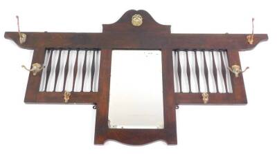 A late Victorian oak framed wall mounted coat rack, with a central rectangular bevelled glass mirror, with six hanging hooks, 67cm high, 122cm wide.