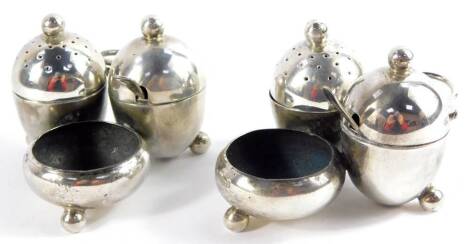 A pair of Victorian silver cruets, of three section integral form, with loop scroll handles, each of ovoid form, raised on a ball foot, comprising pepperette, salt cellar and mustard pot with spoon, Horace Woodward & Company, London 1878., 9.12oz.