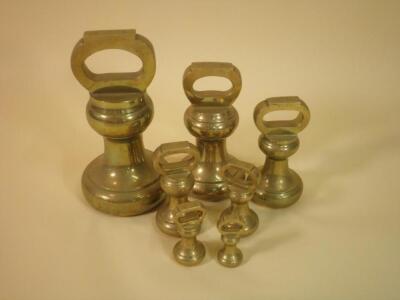 A set of seven brass bell shaped weights