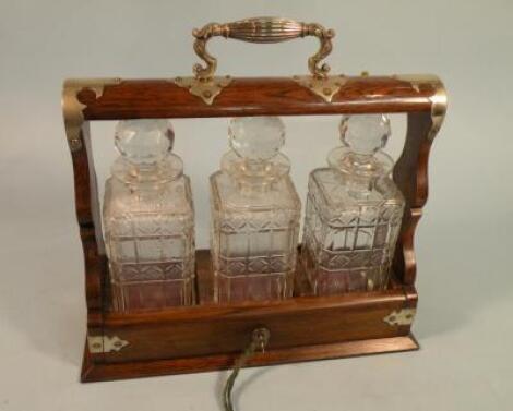 An Edwardian oak tantalus with silver plated mounts containing